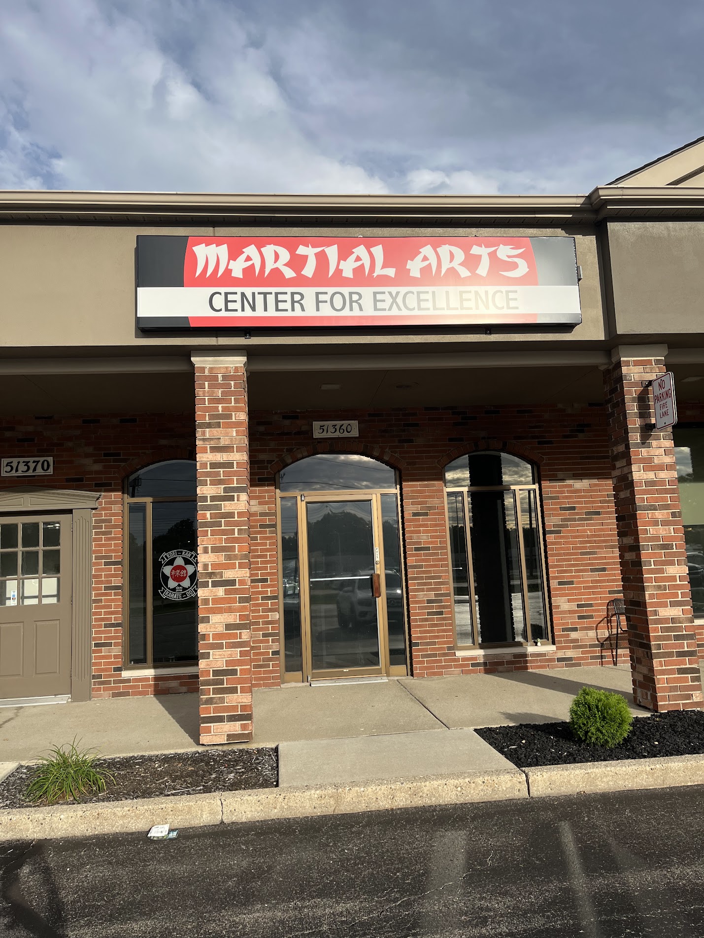 Dojo entrance beneath the Martial Arts Center for Excellence sign, with 51360 above the door